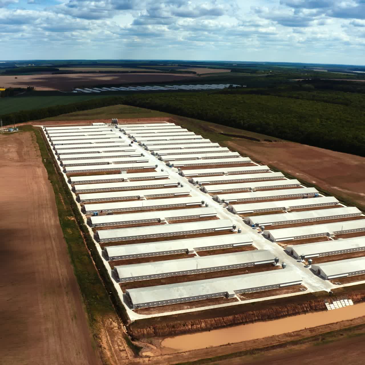 Contemporary outdoor factory in spring. Large territory of a modern industrial plant on the field on nature background. Aerial view.