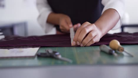 mixed race woman taking measure in fashion office