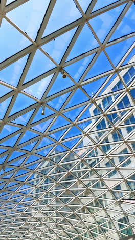 unique glass design with skyline views. visitors admire a striking glass and metal design that frames the blue sky above, enhancing the urban landscape below