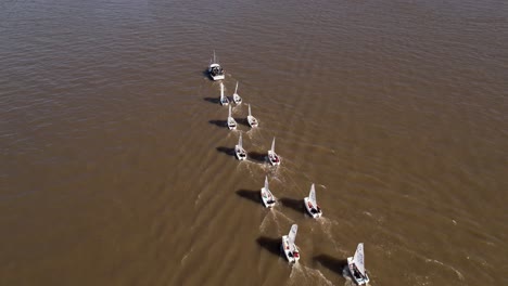 Optimist-Schlauchboote-Werden-Von-Einem-Motorboot-Geschleppt---Luftaufnahme