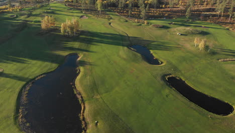 Revelando-Un-Hermoso-Campo-De-Golf-Desde-Lo-Alto-Con-Pequeños-Lagos,-Bunkers-Y-Calles