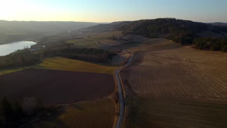 Camino-Sinuoso-Alrededor-De-La-Represa-Křetínka-Letovice,-Campos-Y-Bosques-Al-Atardecer-Dorado-Y-Tranquilo,-República-Checa---Vista-Aérea