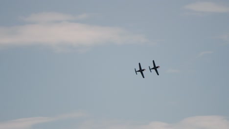 Slow-motion-tracking-shot-of-a-pair-of-Patrouille-de-France-pilots-flying-in-unison