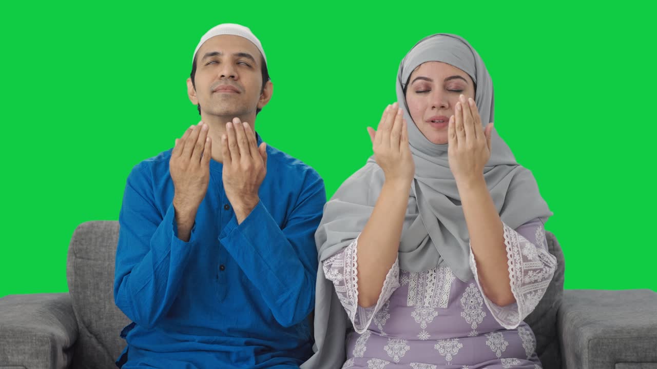 무슬림 부부가 집에서 나마즈를 읽고 있는 녹색 화면