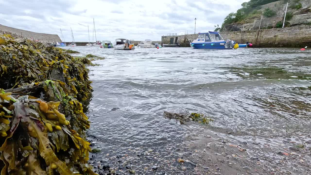 Waves hitting pier with boats docked