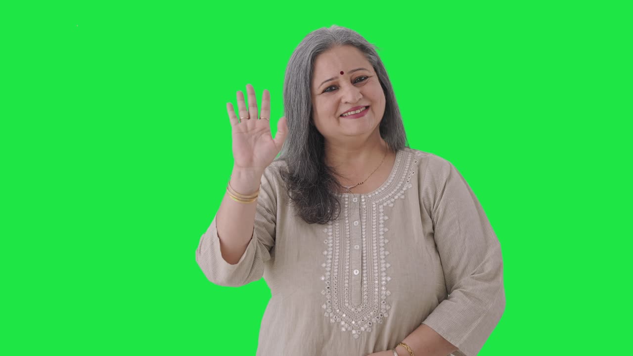vieja india feliz saludando y diciendo hola pantalla verde