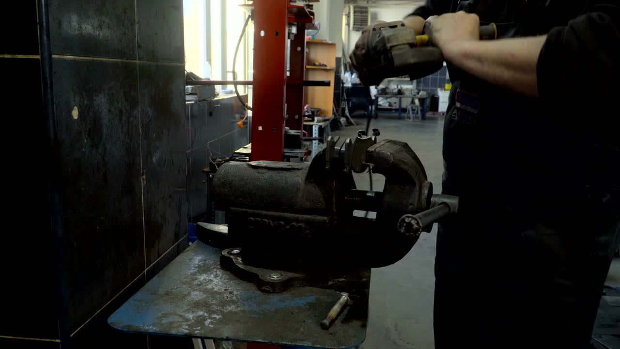 Closeup of worker using a grinder cuts metal in a workshop