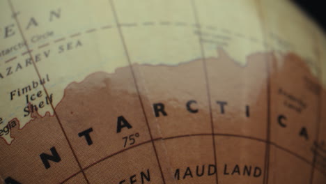 close-up of a vintage world globe focused on antarctica