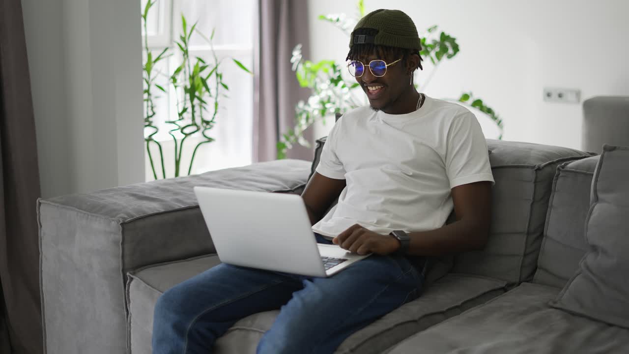 Black man works at a laptop, makes video conferences or video call