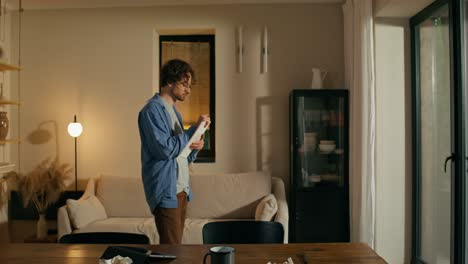 man writing in living room at night