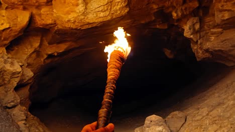 una persona sosteniendo una antorcha en una cueva