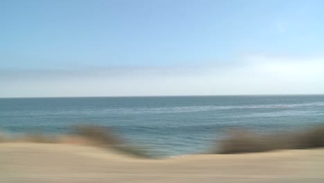 a car travels along pacific coast highway as seen through the side window 9