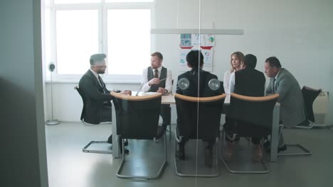 gruppe von geschäftsleuten, die während des geschäftstreffens im büro gemeinsam am tisch diskutieren