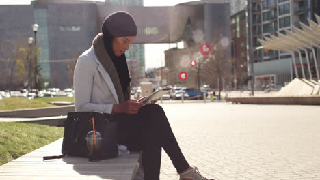 animación de una mujer de raza mixta con hijab en la calle usando una tableta con un símbolo de corazón flotante