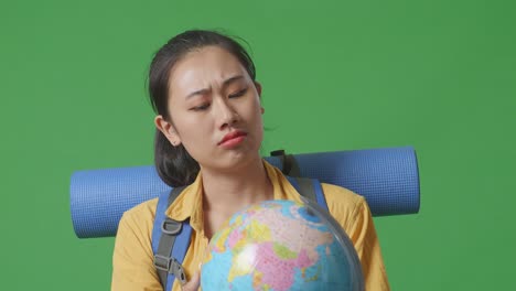 mujer mirando un globo con confusión
