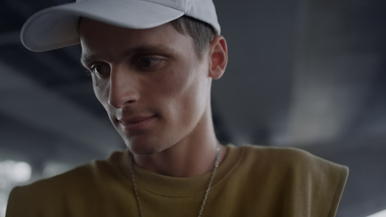 즐거운 밀레니얼 세대가 스케이트파크에서 여름 모자를 입고 스마트폰으로 웹 서핑을 합니다.