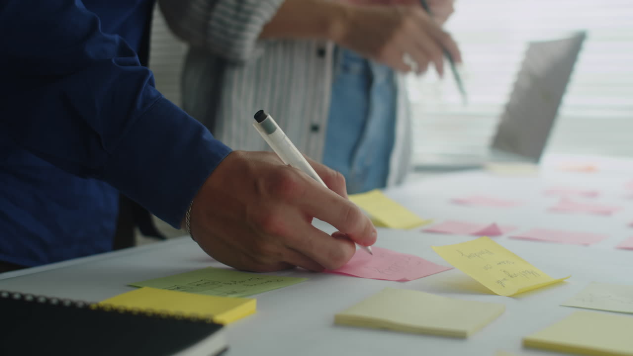 Hand of Entrepreneur Writing Ideas on Sticker Working with Colleague