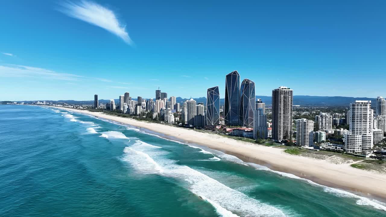 Una splendida vista aerea del sobborgo di Main Beach in una giornata di sole, catturata da un drone che vola verso sud, che mostra sabbie dorate, onde oceaniche blu e una costa vivace. Queensland iconico