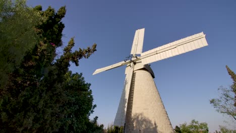 approaching the old traditional stone windmill montefiore windmill in the jerusalem countryside, seen from below, then going backwards