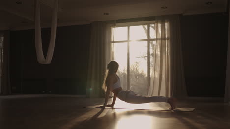 Una-Mujer-Joven-Hace-Ejercicio-Realizando-Ejercicios-De-Yoga-En-Cámara-Lenta-Bajo-La-Luz-Del-Sol.-Luz-A-Través-De-La-Ventana-Luz-Del-Sol