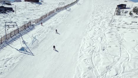 slow motion shot of people skiing down a ski slope alongside a ski lift in the farellones