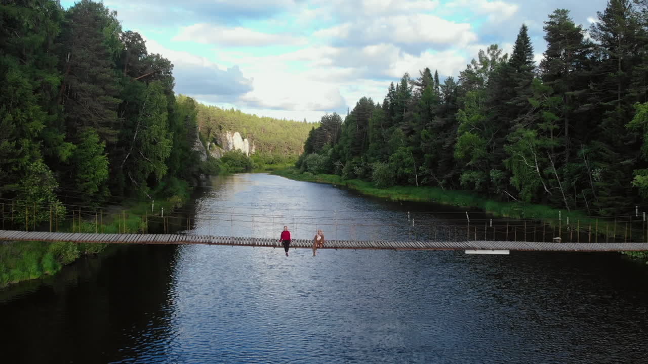Ihmisiä riippusillalla joen yllä