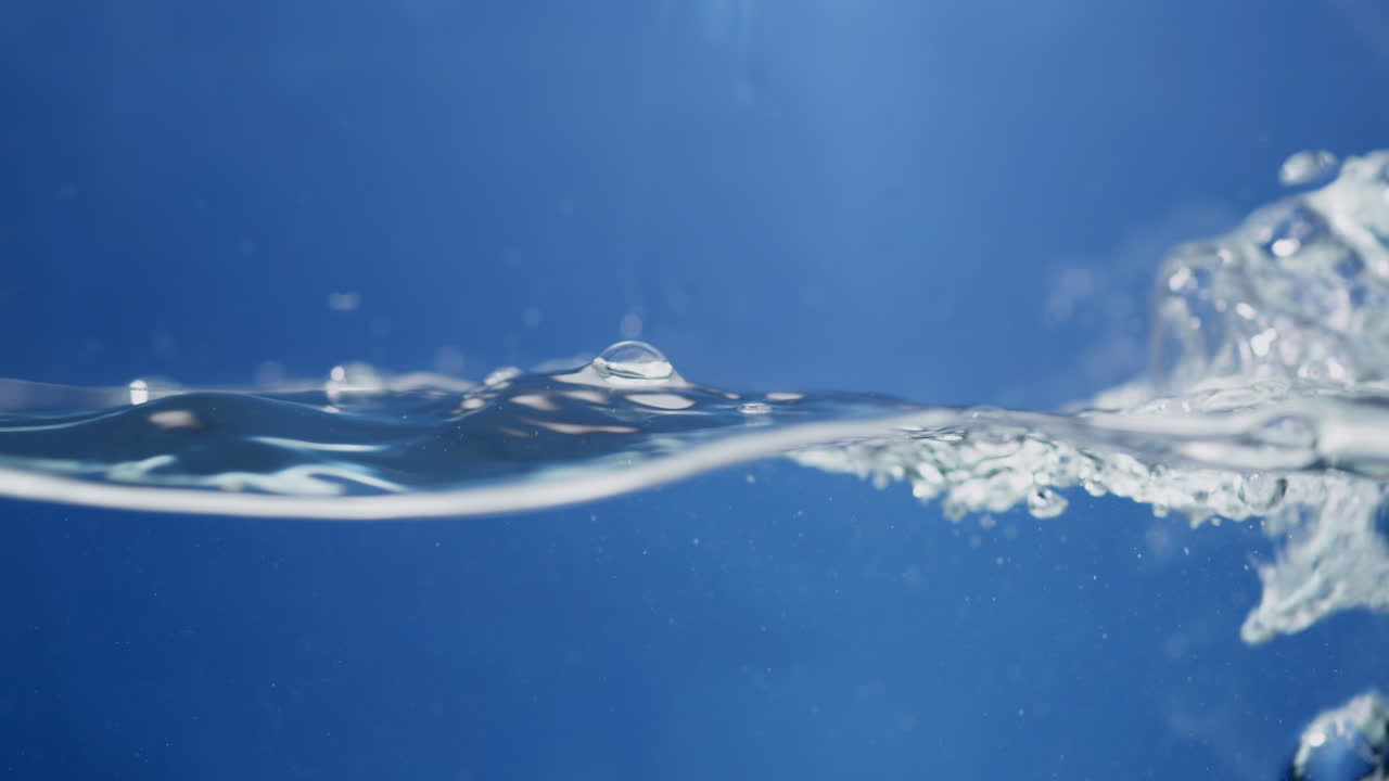 크리스탈처럼 은 푸른 물의 물결이 아지고 은 물의 작은 물방울과 거품으로 어지고 있습니다.