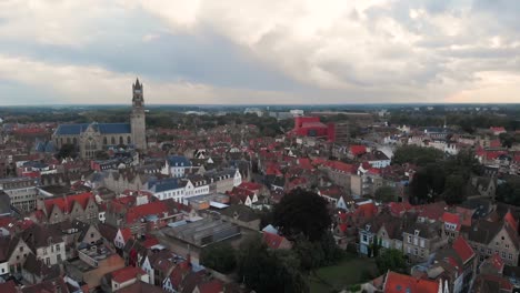 flying over the ancient city of bruges with a cloudy sky, belgium, drone shot hd