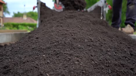 Close-Up-Shot-Of-Topsoil-Being-Shovelled-From-Trailer-Onto-The-Garden