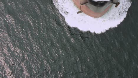 vista aérea de un petrolero vacío que pasa por debajo de un puente hacia un puerto