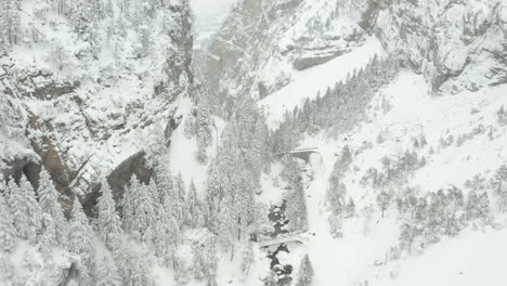 Drone-Volando-Entre-Montañas-Cubiertas-De-Nieve-En-Invierno