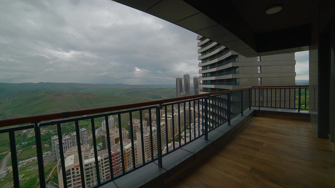 Pemandangan dari Balkon Apartemen Bertingkat Tinggi Modern yang Menghadap Kota