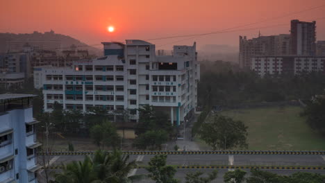 Navi-Mumbai-Seawood-sunrise-behind-tilak-group-of-instituted-seawoods-bridge-traffic-car-passing-orange-sky