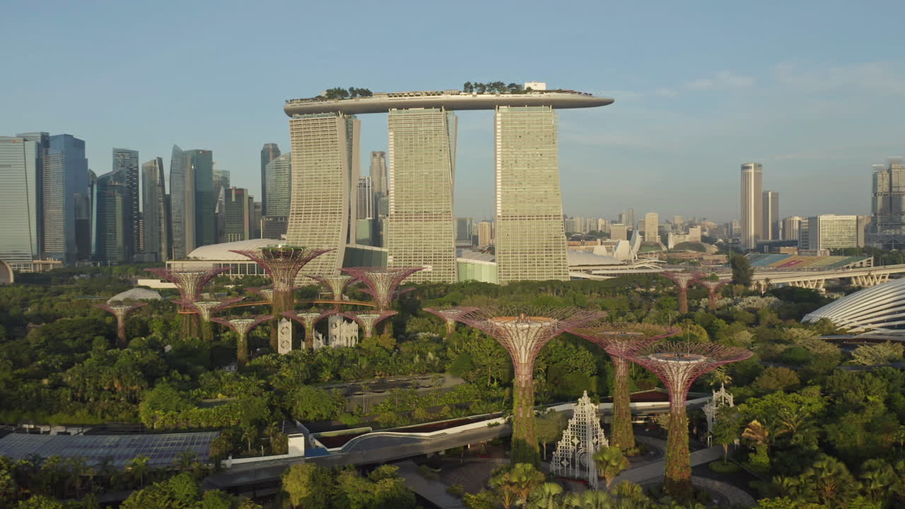 отель marina bay sands на восходе солнца с супердеревьями на переднем плане