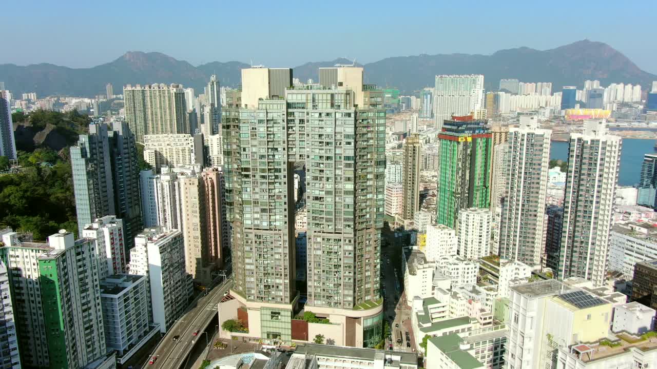 toma aérea de mega rascacielos residenciales y tráfico en el centro de hong kong, en un hermoso día