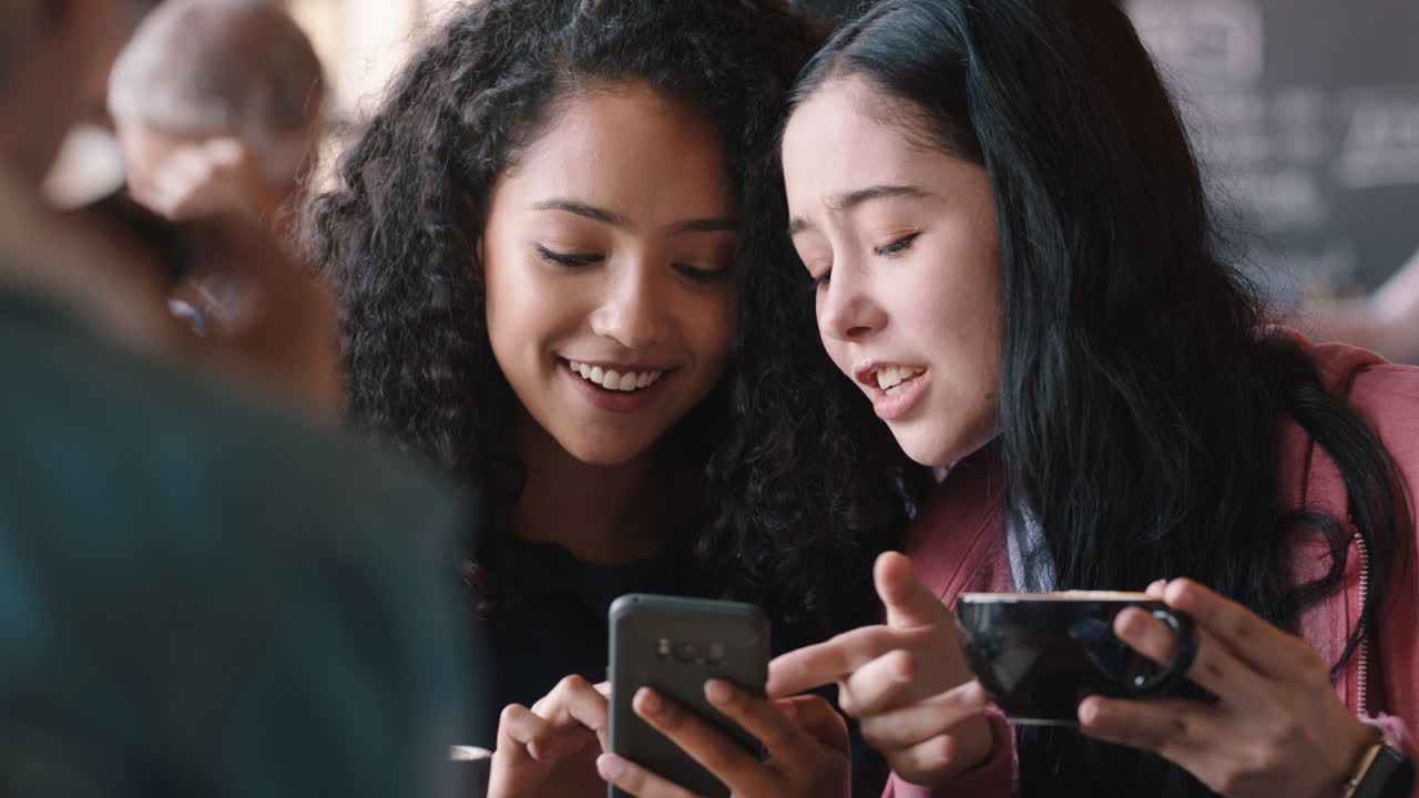 amigas adolescentes felices usando teléfonos inteligentes bebiendo café en un café enviando mensajes de texto compartiendo chismes disfrutando de charlar juntas