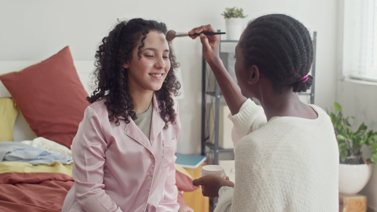 Mujer negra maquillando la cara de una amiga