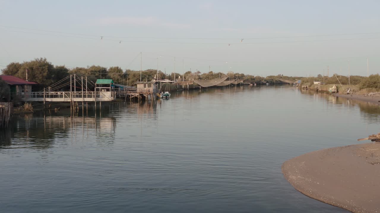 cabañas de pescadores con redes de pesca y equipos de pesca en el río por la mañana, lido di dante, fiumi uniti, ravenna cerca del valle de comacchio