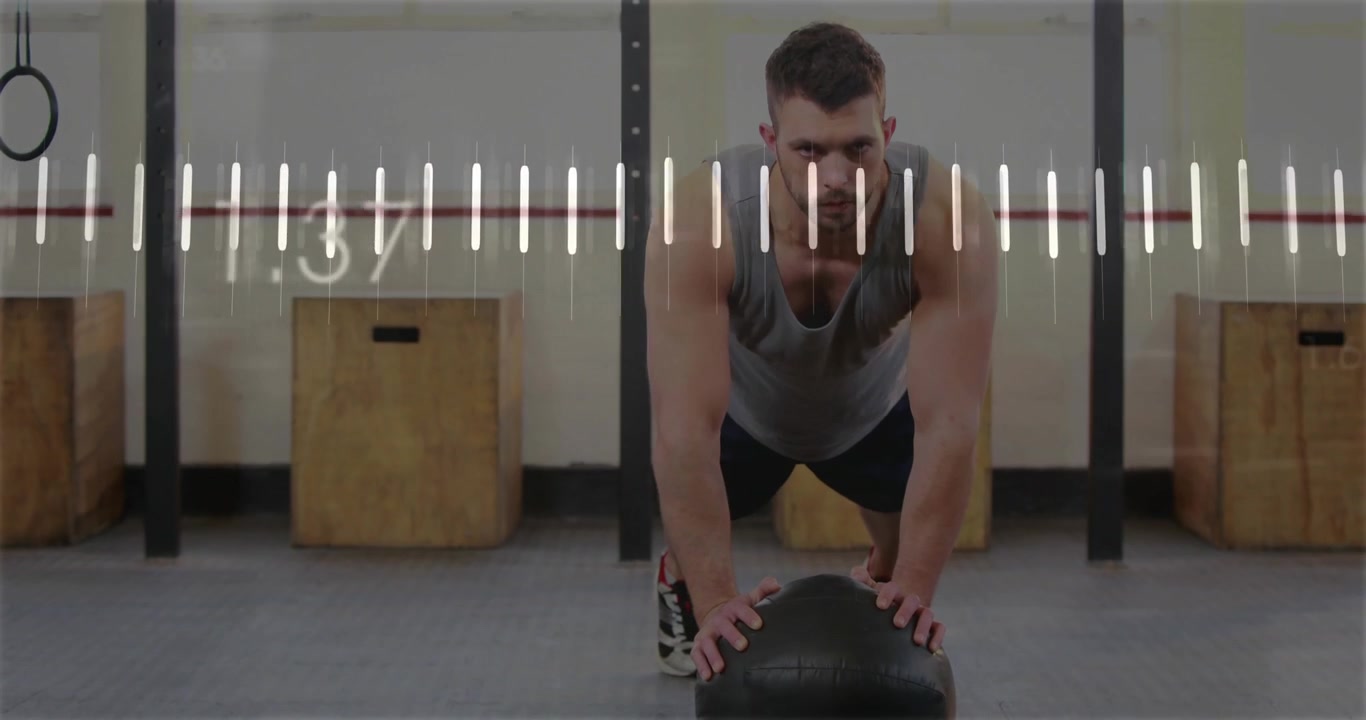 Man balancing on med ball doing push-ups and generating realtime fitness graphs for tracking in gym