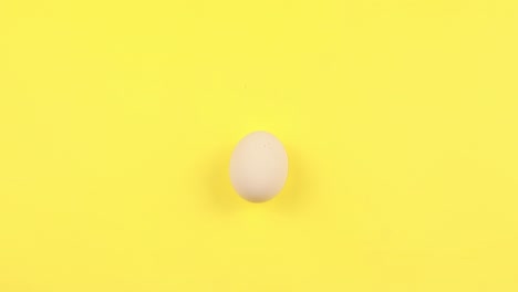 on a yellow background, four white chicken eggs