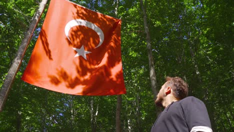 ziviler junger mann, der die türkische flagge begrüßte.