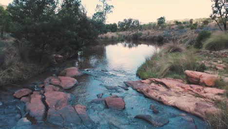 rocky ford over small river in african landscape, forward dolly shot