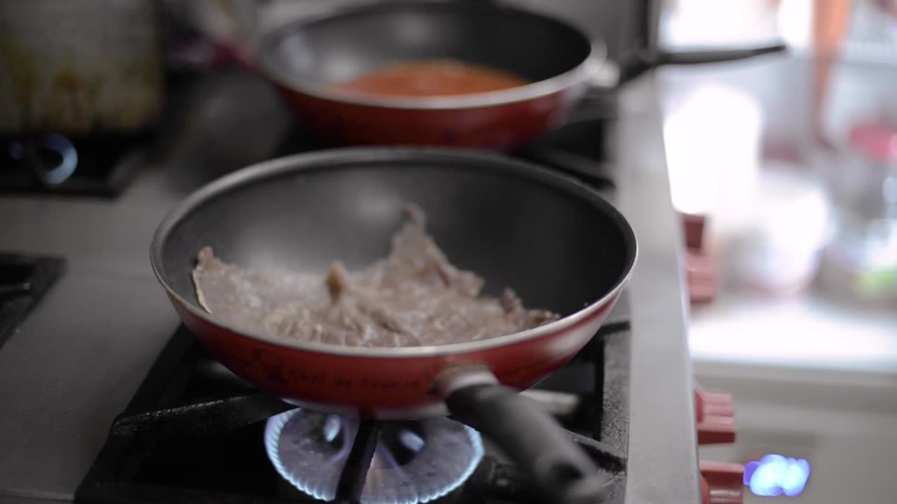 Close up of a Man Chef cook cooking frying roasting meat steak on a teflon pan at a local diner cafe restaurant in Mexico Latin america
