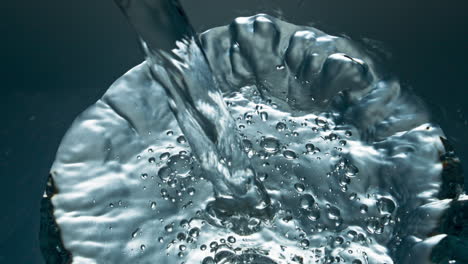 mineral water pouring transparent glass closeup. blebs going up smooth liquid