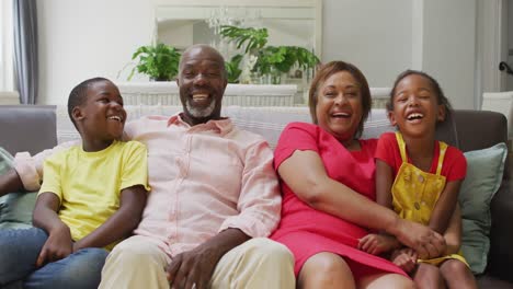 Glückliche-Afroamerikanische-Großeltern-Und-Enkelkinder,-Die-Sich-Auf-Dem-Sofa-Umarmen