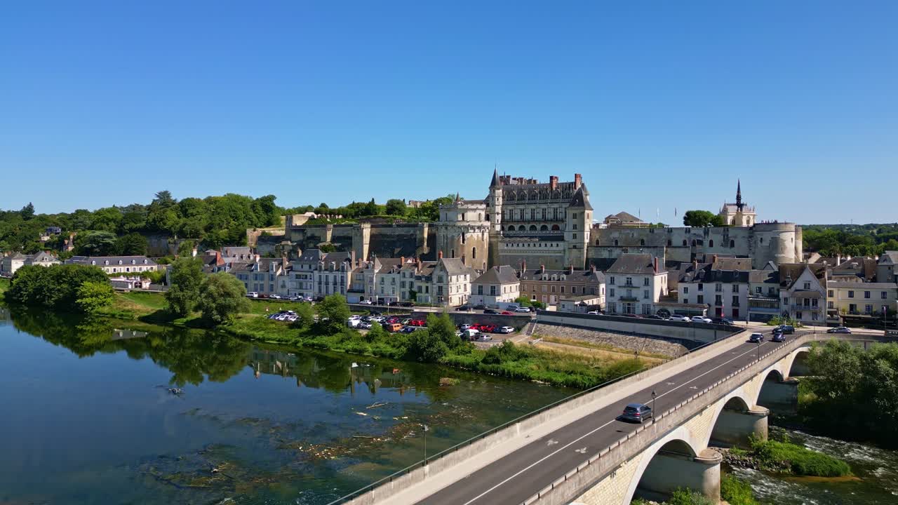 Royal Chateau of Amboise with nearby bridge crossing Loire River, wide aerial ascend establish
