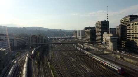 aerial establishing shot of trains arriving at central rail station in european city