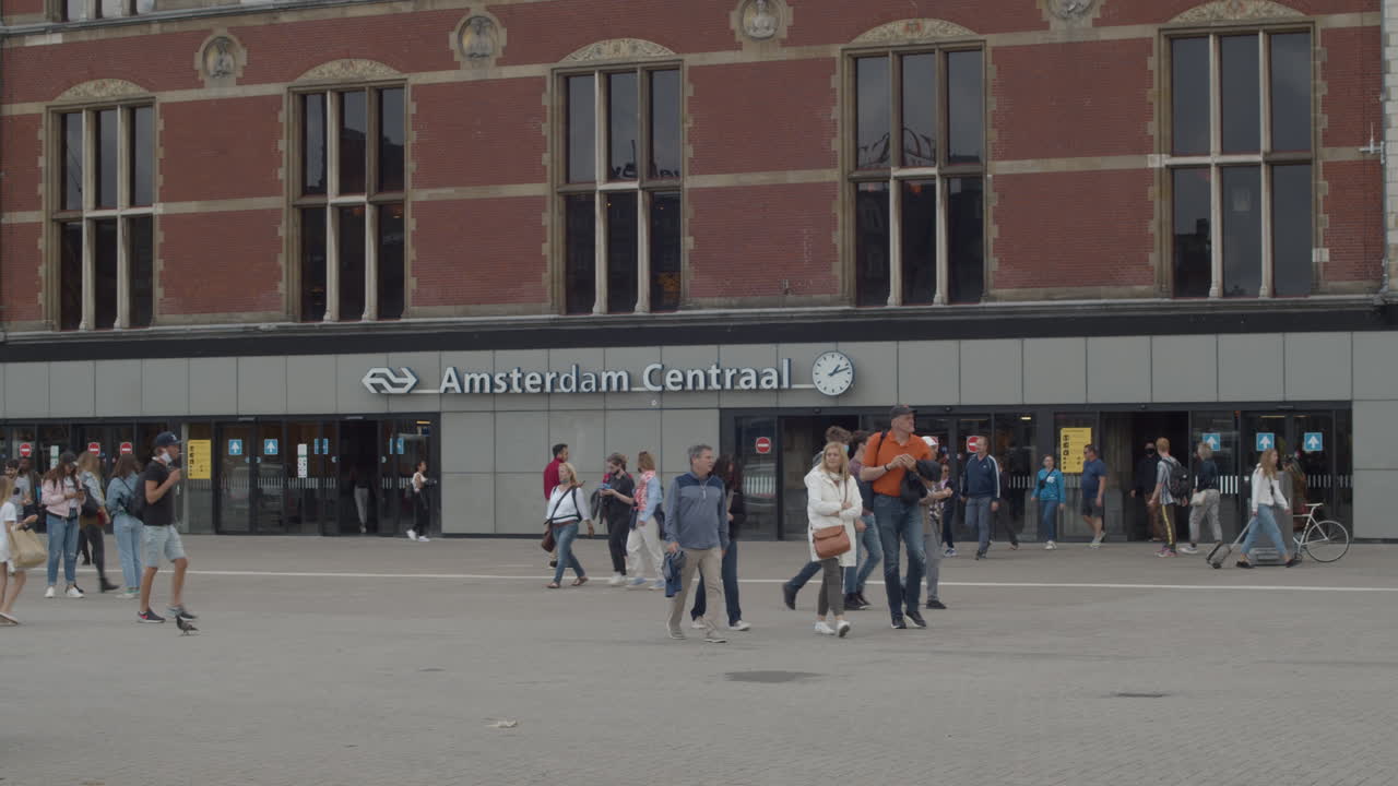 People walking in front of main entrance of Amsterdam central train station