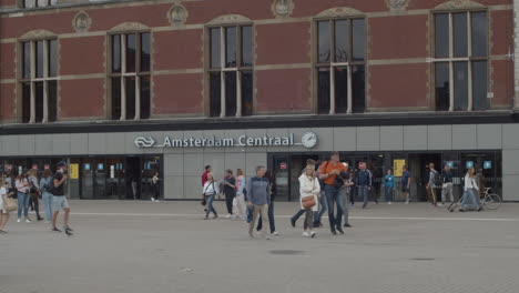 people walking in front of main entrance of amsterdam central train station