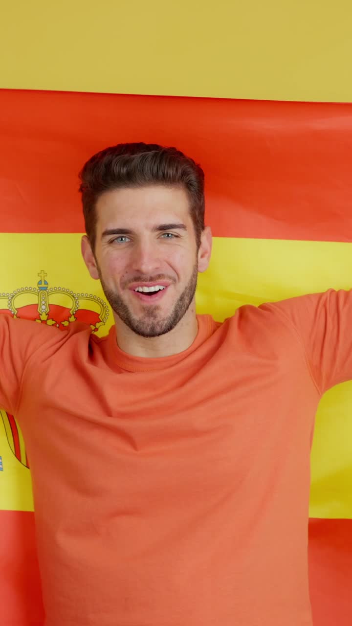 Enthusiastic man cheering with a Spanish flag